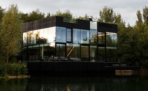 Стеклянный дом на озере создает впечатление плывущего по воде