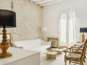Белая квартира-студия с кирпичной стеной и антикварными креслами в Барселоне (60 кв. м)