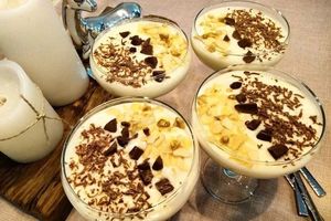 Сливочный десерт с орехами, лимонным соком и печеньем в стакане