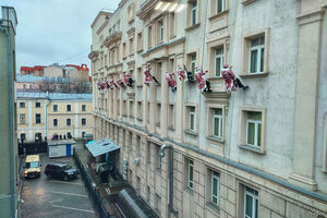 Деды Морозы спускаются с крыши больницы и машут детям в окна