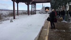 Поезд, прибывающий на вокзал, засыпал снегом стоявших на перроне